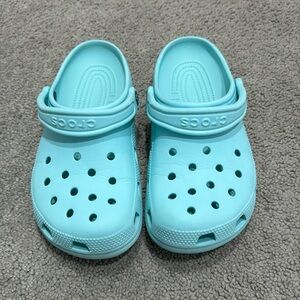 one pair of crocs (size: women 7, men 5) in light blue